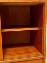 Load image into Gallery viewer, Close-up of the interior of a wooden bookcase or cabinet with two shelves, showing warm medium-brown wood grain and a reddish-brown inner lining.
