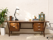 Load image into Gallery viewer, Mid-century style walnut executive desk with five drawers, chrome-tone pulls, angled sculptural legs, and long wood desktop.
