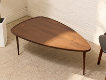 Load image into Gallery viewer, Mid-century style walnut coffee table with asymmetrical biomorphic top, warm wood grain, and slim tapered legs.

