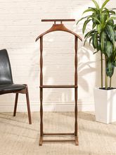 Load image into Gallery viewer, Vintage walnut gentleman’s valet stand with sculptural wood hanger, trouser bar, lower rack, and slim mid-century frame.
