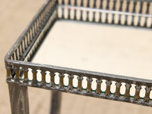 Load image into Gallery viewer, Close-up of a decorative metal side table frame with a balustrade-style apron and a light beige tabletop, photographed against a neutral beige background.
