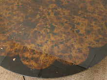 Load image into Gallery viewer, A close-up of a round table top with a mottled brown and black marbled pattern, showing some wear and scuffs on the surface.
