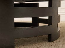 Load image into Gallery viewer, Close-up of a black wooden table leg with horizontal slat details, standing on a woven beige rug.
