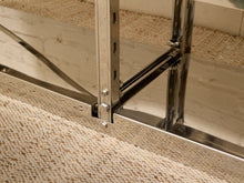 Load image into Gallery viewer, Close-up of a polished stainless steel industrial staircase frame with carpeted steps and a white brick wall background.
