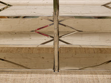 Load image into Gallery viewer, Close-up of a modern metal staircase railing with polished chrome vertical posts and geometric silver handrails, mounted against a white brick wall above a beige carpet.
