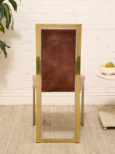 Load image into Gallery viewer, A tall rectangular floor mirror with a brushed gold metal frame and a dark brown velvet backrest, shown leaning against a white brick wall in a styled room setting.
