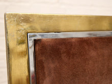 Load image into Gallery viewer, Close-up of a vintage brass picture frame with a brown suede or velvet upholstered backing and a polished silver metal inner trim.
