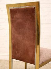 Load image into Gallery viewer, A close-up of a chair back featuring a warm brown suede or velvet upholstered panel set within a polished gold-tone metal frame, with a textured mauve-pink seat cushion partially visible.
