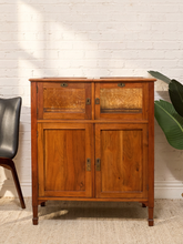 Load image into Gallery viewer, A mid-century modern wooden sideboard cabinet with two upper doors featuring decorative inlay panels and two lower solid wood doors, set against a white brick wall.
