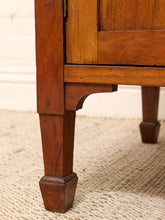 Load image into Gallery viewer, Close-up of a wooden cabinet leg with a turned square foot and decorative bracket support, resting on a woven beige rug.
