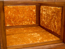 Load image into Gallery viewer, Close-up of the interior corner of a wooden cabinet or shelf, lined with textured golden-orange velvet fabric on the back panels and floor.
