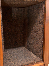Load image into Gallery viewer, Close-up of the interior corner of a wooden cabinet or shelf with dark brown and black speckled lining on the walls and floor.
