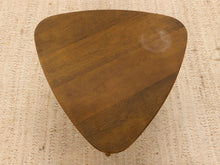 Load image into Gallery viewer, A triangular wooden table top with rounded corners, featuring a warm medium-brown wood grain finish, photographed from directly above on a textured beige woven rug.
