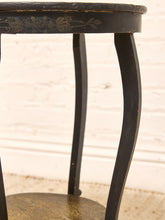 Load image into Gallery viewer, Close-up of a dark painted wooden table leg with curved legs and a distressed finish, set against a white brick wall background.
