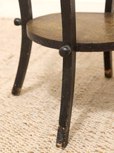 Load image into Gallery viewer, Close-up of a dark wood chair leg and seat with round black knobs, resting on a textured cream woven rug.
