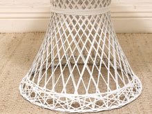 Load image into Gallery viewer, White woven rattan table skirt with a diamond lattice pattern, shown on a burlap rug in front of a white brick wall.
