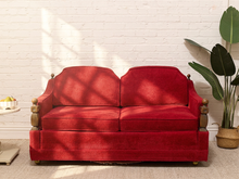 Load image into Gallery viewer, Vintage 1970s red upholstered loveseat with oversized seat and back cushions, exposed wood arm details, and rounded wood finials.
