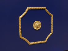 Load image into Gallery viewer, A gold octagonal decorative frame with a textured rope-like border and a matching small flower-shaped medallion in the center, set against a solid deep blue background.
