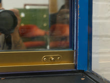 Load image into Gallery viewer, Close-up of a window frame with a gold metal lock and a blue painted frame, showing reflections of a person taking the photo.
