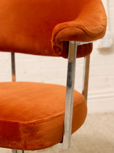 Load image into Gallery viewer, Close-up of a mid-century modern accent chair with a burnt orange velvet seat and backrest, supported by a polished chrome metal frame.
