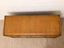 Load image into Gallery viewer, A rectangular wooden chest or bench with a warm medium-brown wood finish, photographed from above against a white brick wall and beige rug.
