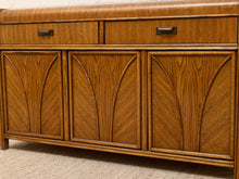 Load image into Gallery viewer, A mid-century modern wooden sideboard or credenza with three drawers on top and three arched leaf-shaped cabinet doors below, shown in a warm medium brown finish on a carpeted floor.

