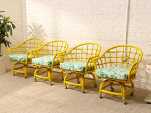 Load image into Gallery viewer, Image 2 of 20: Set of four vintage bright yellow rattan barrel chairs with curved lattice backs and green botanical print cushions
