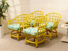 Load image into Gallery viewer, Image 4 of 20: Set of four vintage bright yellow rattan barrel chairs with curved lattice backs and green botanical print cushions
