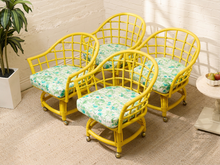 Load image into Gallery viewer, Image 5 of 20: Set of four vintage bright yellow rattan barrel chairs with curved lattice backs and green botanical print cushions
