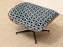 Load image into Gallery viewer, A modern lounge ottoman with a curved wooden shell, black metal star base, and a black fabric seat upholstered in a light blue and white geometric lattice pattern, shown on a beige textured rug.

