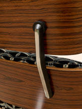 Load image into Gallery viewer, A close-up of a modern matte black metal drawer pull handle mounted on a dark wood grain cabinet door, with a black and gray patterned runner strip underneath.
