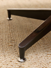 Load image into Gallery viewer, Close-up of a dark brown wooden table leg with a silver metal round base, resting on a textured beige woven rug.
