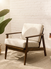 Load image into Gallery viewer, Vintage mid-century lounge chair with walnut-toned wood frame, sculpted open arms, and cream bouclé cushions
