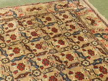 Load image into Gallery viewer, A traditional Persian-style area rug with a beige background, featuring red floral motifs, blue and brown geometric borders, and a detailed repeating pattern.
