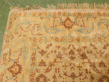 Load image into Gallery viewer, A close-up of a traditional patterned rug with a warm beige base, brown motifs, and light blue accents, featuring fringed edges.
