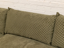Load image into Gallery viewer, Close-up of a woven fabric sofa cushion in an olive green and beige checkerboard pattern, set against a white brick wall background.
