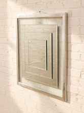 Load image into Gallery viewer, A rectangular wall mirror with a distressed silver frame, mounted on a white painted brick wall.
