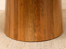Load image into Gallery viewer, Close-up of a round wooden stool or table base made from vertical stained wood panels, standing on a woven beige rug.
