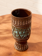 Load image into Gallery viewer, A brown ceramic goblet with a textured, ribbed design and turquoise glaze accents, displayed on a wooden surface.
