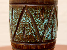 Load image into Gallery viewer, Close-up of a ceramic vase with a dark brown textured base and a turquoise blue-green speckled glaze pattern featuring a geometric zigzag design.
