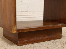 Load image into Gallery viewer, Close-up of a dark brown wooden furniture piece, showing the corner support, shelf, and base on a textured beige carpet against a white brick wall.

