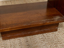 Load image into Gallery viewer, A close-up of a dark brown wooden box or drawer front with visible wear and scratches on the surface, resting on a woven beige rug.

