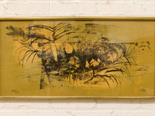 Load image into Gallery viewer, A framed abstract painting featuring black and dark brown brushstrokes on a textured gold background, mounted on a white brick wall.
