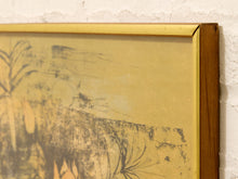 Load image into Gallery viewer, A close-up of a framed art print with a textured gold background and dark abstract brushstrokes, set in a wooden frame against a white textured wall.
