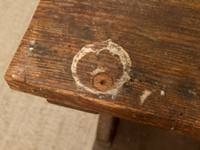 Load image into Gallery viewer, Close-up of a rustic dark brown wooden table corner showing a circular white paint mark over a screw head, with a beige carpet visible in the background.
