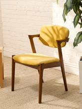 Load image into Gallery viewer, Image 7 of 89: Modern Trex armchair with golden velvet upholstered seat and rounded back, sculpted wood arms, and tapered wood legs
