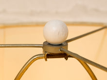 Load image into Gallery viewer, Close-up of a white spherical finial mounted on a brass metal frame, with a warm beige background.
