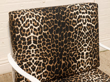 Load image into Gallery viewer, Leopard print upholstered chair cushion on a white armchair, shown against a white brick wall background.

