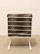 Load image into Gallery viewer, Vintage lounge chair with brown and black leopard print upholstery, white sculptural frame, and curled scroll arms
