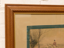 Load image into Gallery viewer, Close-up of a framed art print featuring a vintage equestrian scene with a rider on horseback, surrounded by a warm brown wood frame and beige matting.
